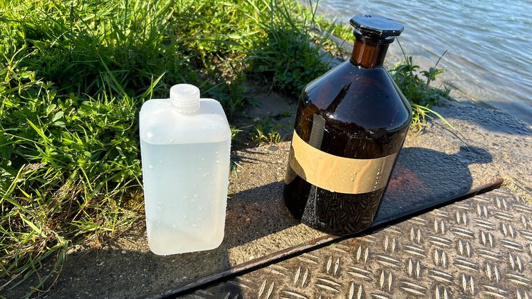 Eine weiße Flasche aus Kunststoff und eine braune aus Glas soll die Kontamination der Proben aus dem Rhein verhindern.
