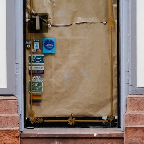 Der Eingang und die Schaufensterfront eines Geschäfts in der Hauptstraße, einer Fußgängerzone und Einkaufsstraße in der Heidelberger Innenstadt, ist mit Papier beklebt. 