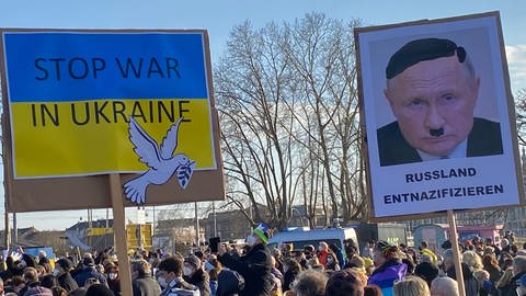 Solidarität mit der Ukraine: Menschen demonstrierten in Mannheim unter anderm mit einem Plakat, auf dem der russische Präsident Wladimir Putin mit Hitler verglichen wird. (Foto: SWR, Philipp Behrens)