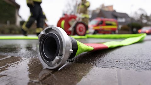 Feuerwehrschlauch liegt auf dem Boden (Foto: picture-alliance / Reportdienste, picture alliance/Friso Gentsch/dpa)
