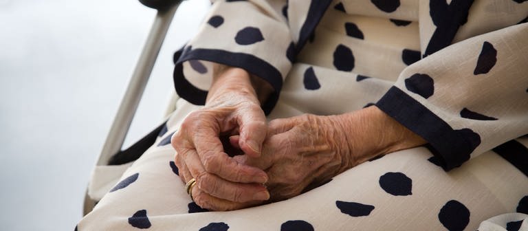 Ältere Frau legt die hände auf den Schoß (Foto: dpa Bildfunk, Frank Rumpenhorst)