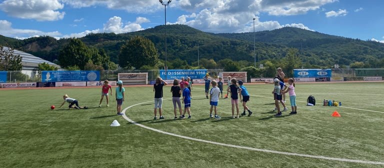 Die Kinder toben sich beim Sommerferien-Camp in Dossenheim (Rhein-Neckar-Kreis) ordentlich aus. Auf dem Sportplatz wird zum Beispiel Brennball gespielt.  (Foto: SWR)