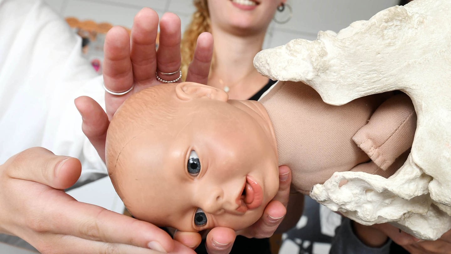 In einer Hebammenschule lernen zukünftige Hebammen die Geburtsmechanik mithilfe einer Puppe. (Foto: dpa Bildfunk, picture alliance / Uli Deck/dpa | Uli Deck)