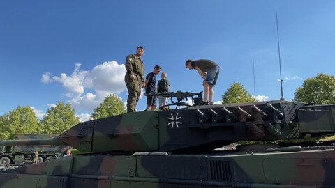 Bei der Verabschiedung des Panzerbatallion 363 Hardheim zum NATO-Einsatz nach Litauen zeigt ein Soldat Interessierten aus der Bevölkerung einen Panzer (Foto: SWR, SWR/ Thomas Miltner)