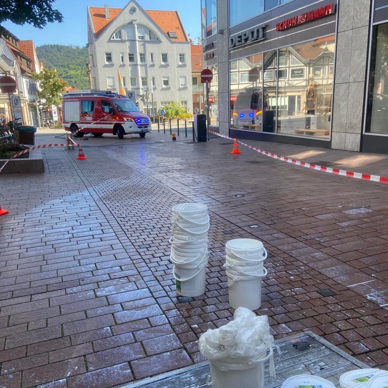 Abgesperrte Fußgängerzone mit ausgelaufener Milch und Eimern in Weinheim (Foto: Feuerwehr Weinheim)