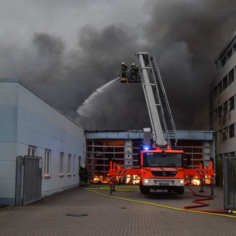 Feuer und Rauchwolken sowie Feuerwehrauto vor Fabrikhalle (Foto: PR-Video, Marco Priebe)