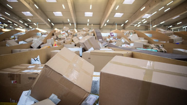 Pakete stapeln sich in einem Paketzentrum (Foto: picture-alliance / Reportdienste, picture alliance/dpa | Tom Weller)
