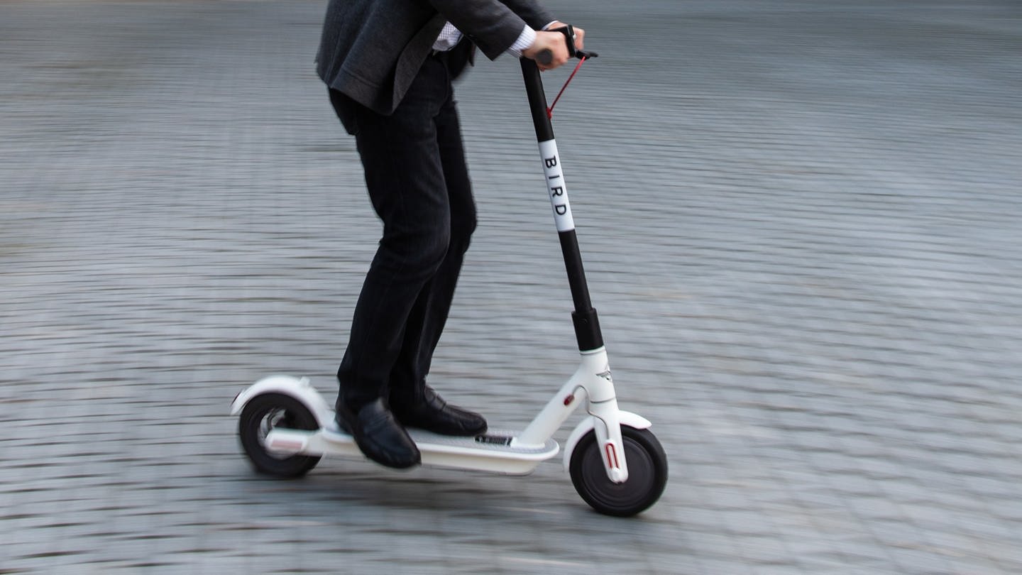 E-Scooter wird von Person in Stadtgebiet gefahren (Foto: dpa Bildfunk, Picture Alliance)