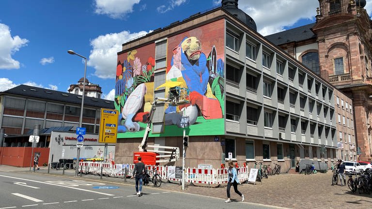 Künstler Azyz malt Löwen-Wandgemälde (mural) an Hauswand in Mannheim