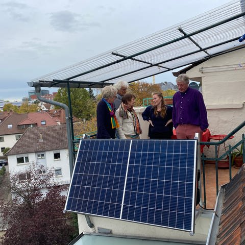 Ein Balkon mit einer Solaranlage in Heidelberg, Personen stehen auf dem Balkon