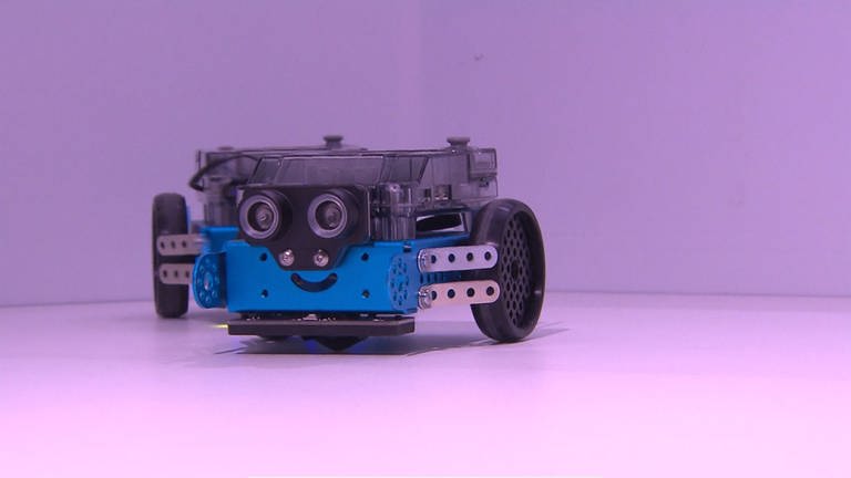 Ein kleiner Roboter, der Bilder und Farben erkennen kann. Er hat zwei Reifen und zwei Kameras als Augen.