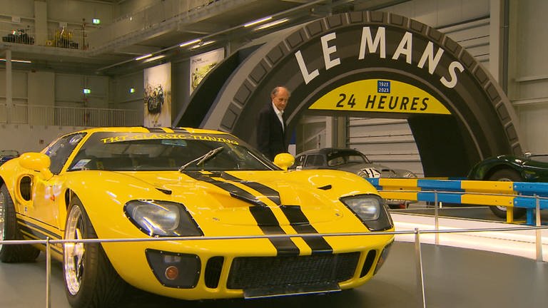 Ein gelber Rennwagen ist neben der Start- und Zieldurchfahrt des 24 Stunden-Rennens von Le Mans im Technikmuseum zu sehen.