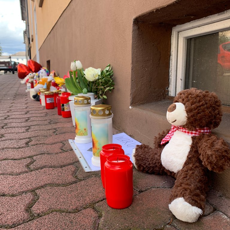 Kuscheltiere und Kerzen auf Bürgersteig in Hockenheim
