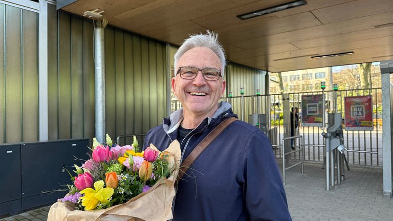 Besucher Ralf Boss aus Mannheim mit Blumenstrauß am Eingang des Luisenparks Bundesgartenschau (Foto: SWR)