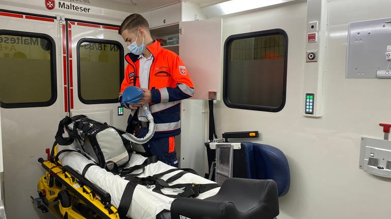 Ein Sanitäter des Malteser Hilfsdienst Heidelberg (MHD) bereitet in einem Krankenwagen einen Krankentransport vor (Foto: SWR)