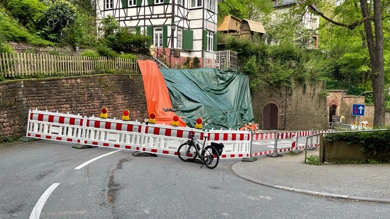 Die vom Hangrutsch betroffene Stützwand ist mit einer Plane abgesichert. Die Mauer ist weiträumig abgesperrt.  (Foto: Stadt Heidelberg)