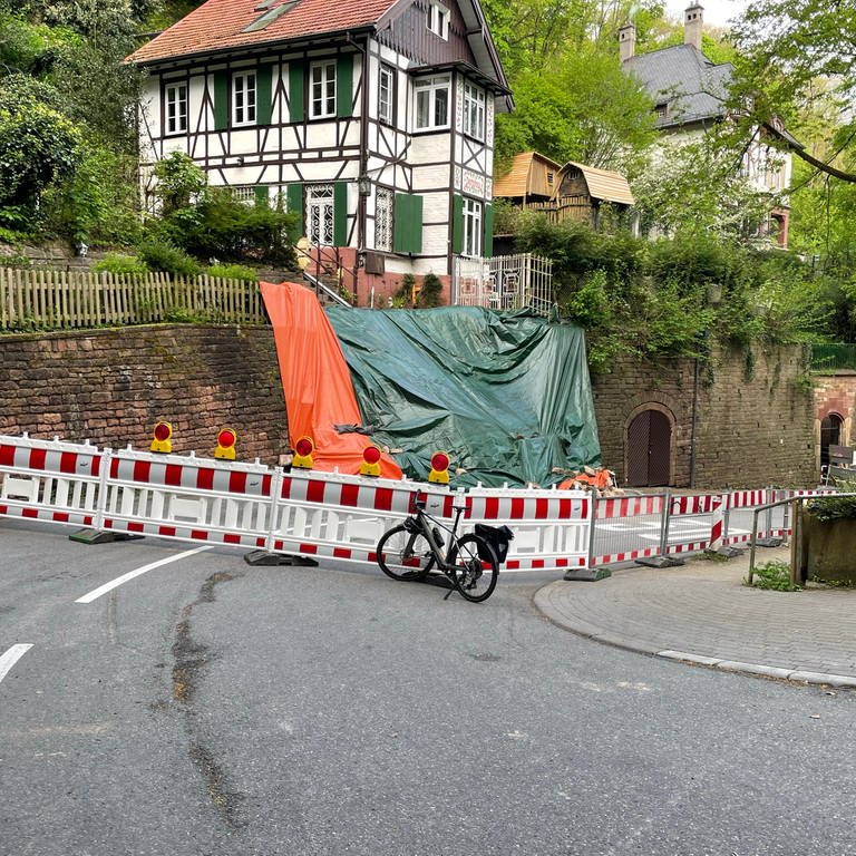 Die vom Hangrutsch betroffene Stützwand ist mit einer Plane abgesichert. Die Mauer ist weiträumig abgesperrt.  (Foto: Stadt Heidelberg)