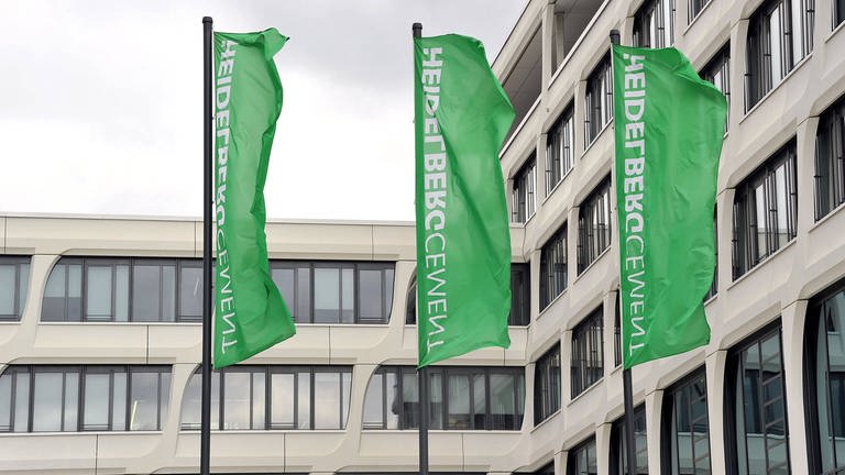 grüne Flaggen vorm HeidelbergCement Sitz. (Foto: IMAGO, IMAGO / STAR-MEDIA)