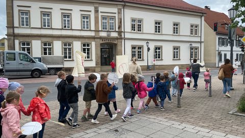 Kinder laufen mit Schildern und Plakaten zum Rathaus in Plankstadt. (Foto: SWR)