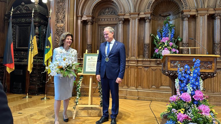 Heidelbergs Oberbürgermeister Eckart Würzner (parteilos) überreicht Königin Silvia die Urkunde. (Foto: SWR, Michaela Dymski)