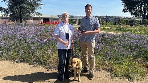 Maria Huber steht zusammen mit ihrem Blindenführhund neben Johannes Britsch, dem Geschäftsführer von contagt (Foto: BUGA 23)