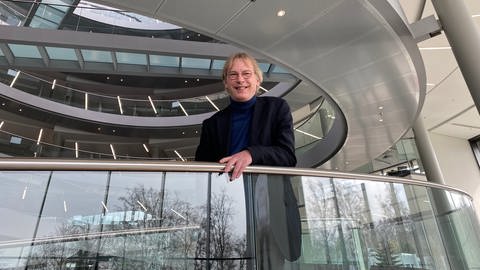 Professor Kräusslich steht an einem Geländer im Universitätsklinikum Heidelberg