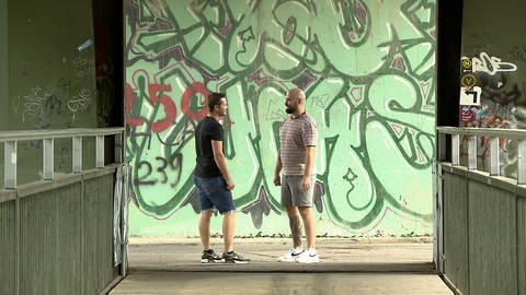 Pfleger Timo Strianese mit Mann vor einer Graffiti-Wand  (Foto: SWR)