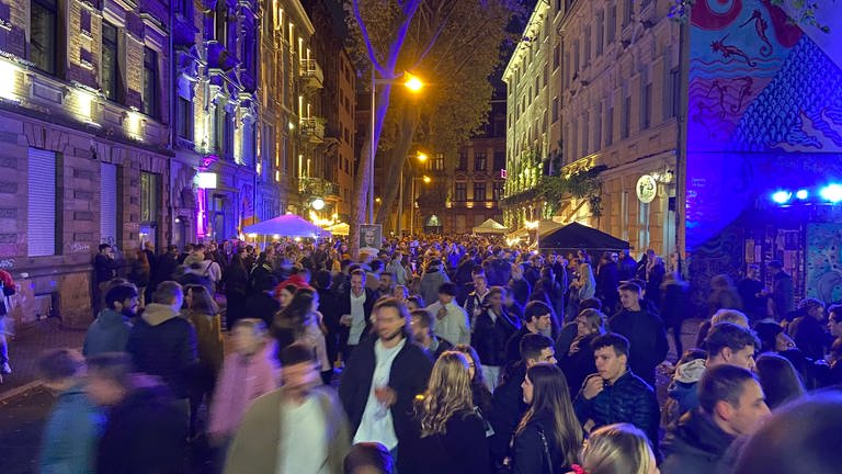 Viele Menschen schlendern nachts durch eine bunt erleuchtete Straße im Stadtteil Jungbusch beim Kulturspektakel Nachtwandel  (Foto: SWR)