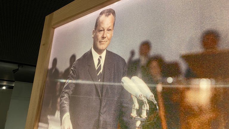 Willy Brandt an Stehpult vor Mikrofonen auf Fotografie