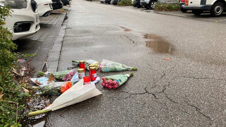 Blumen und Kerzen liegen auf der Straße. (Foto: SWR)