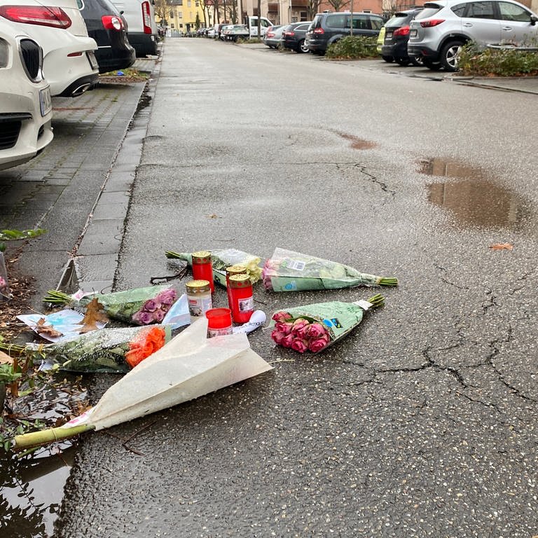 Blumen und Kerzen liegen auf der Straße. (Foto: SWR)