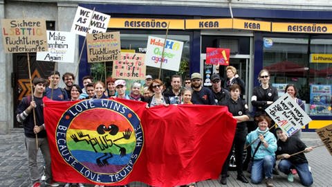 Menschen protestieren beim Christopher Street Day für queere Rechte. Sie haben Schilder und Plakate. (Foto: PLUS Rhein-Neckar (Margret Göth))