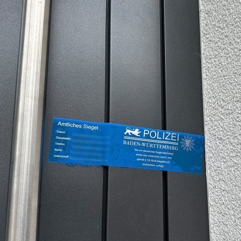Ein Polizeisiegel an der Haustür der Tatverdächtigen in Sandhausen