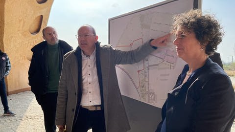 Der Mannheimer Oberbürgermeister Christian Specht zeigt den Verlauf des Zauns auf einer Karte. 
