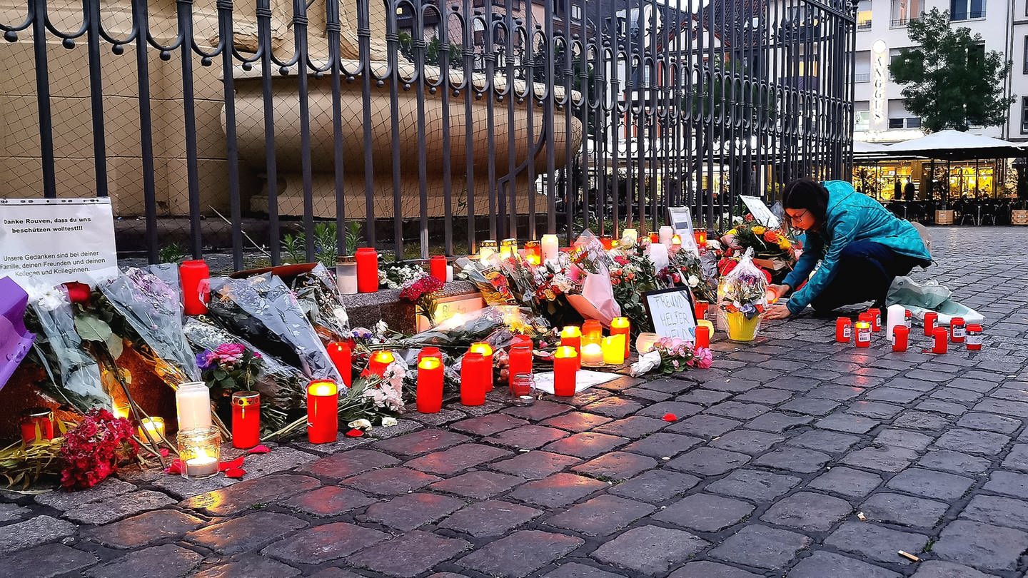 Nach dem Bekanntwerden vom Tod des Polizisten legen am Tatort am Marktplatz Passanten Blumen nieder und zünden Kerzen an. (Foto: dpa Bildfunk, picture alliance/dpa | Dieter Leder)