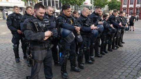 Polizisten in Uniform stehen auf dem Marktplatz in Mannheim um zu trauern