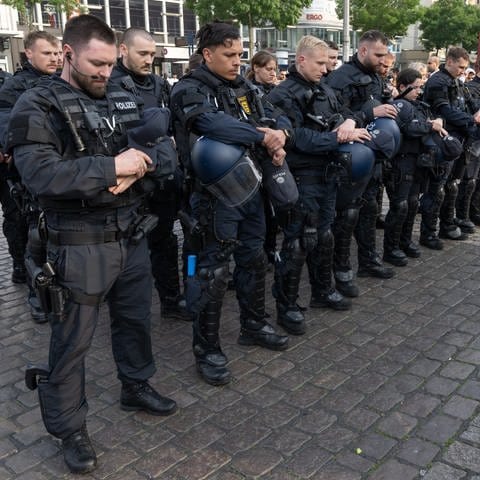 Polizisten in Uniform stehen auf dem Marktplatz in Mannheim um zu trauern