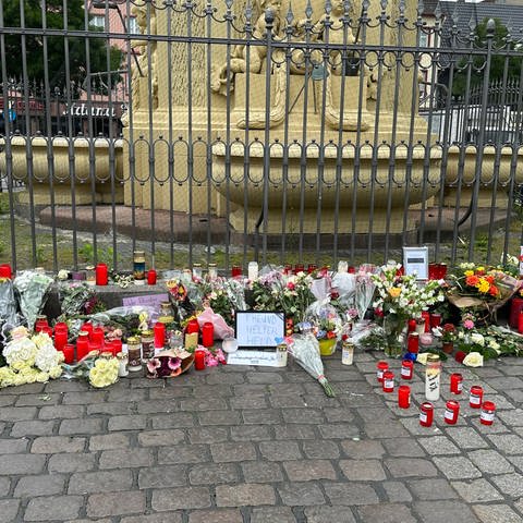 Blumen, Kerzen, Botschaften, Zettel liegen vor dem Brunnen auf dem Marktplatz in Mannheim