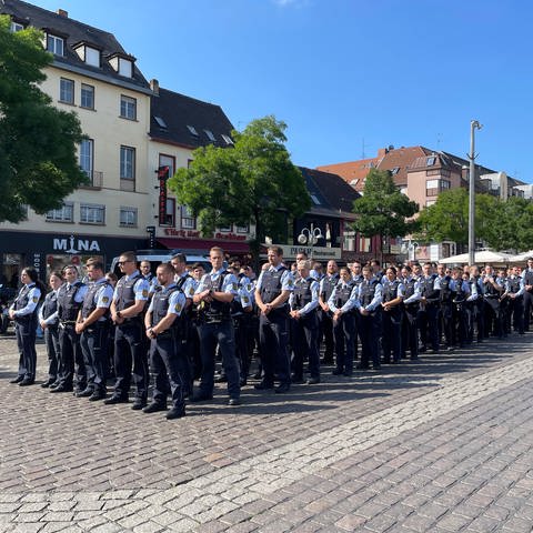 Zahlreiche Polizisten haben sich auf dem Marktplatz im Gedenken an ihren getöteten Kollegen in Reihen aufgestellt