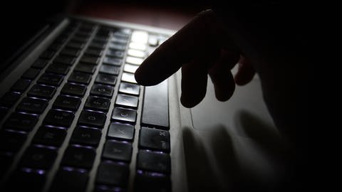 Eine Hand an einer Laptop-Tastatur. Es geht dabei um Cyber-Kriminalität. (Foto: dpa Bildfunk, picture alliance / Karl-Josef Hildenbrand/dpa)