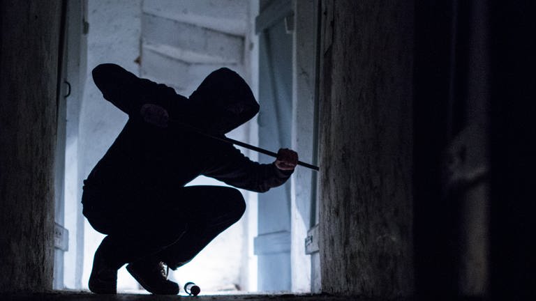  Ein "Einbrecher" hebelt mit einem Brecheisen eine Tür im Keller eines Wohnhauses auf (gestellte Szene). (Foto: picture-alliance / Reportdienste, dpa | Silas Stein (Symbolbild))