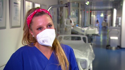 Svenja Luik, Stationsleiterin der Unfallchirurgie des Stuttgarter Marienhospitals, ist eines der Gesichter der Kampagne, mit der das Krankenhaus um neue Fachkräfte wirbt. Sie hat blonde Haare, ein rotes Haarband und trägt einee FFP2-Maske. (Foto: SWR, Katharina Röben)