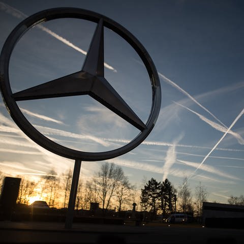 Die Sonne geht hinter einem Mercedes-Stern auf dem Mercedes-Benz-Werk auf. (Foto: dpa Bildfunk, picture alliance/Sebastian Gollnow/dpa)