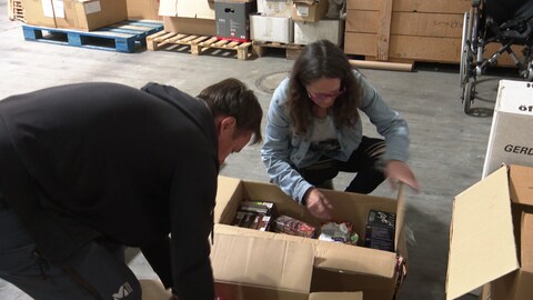 Ein Mann und eine Frau packen einen Karton voll Lebensmitteln für die Ukraine. (Foto: SWR)