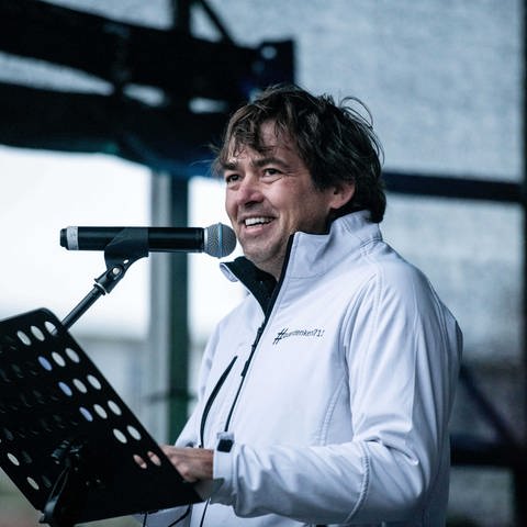 Michael Ballweg spricht 2020 auf einer Bühne in ein Mikrofon. (Foto: dpa Bildfunk, picture alliance/dpa | Fabian Strauch)