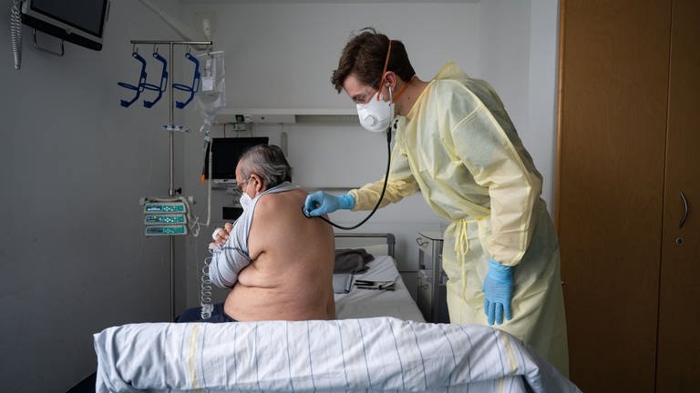 Ein Oberarzt versorgt einen Patienten am Klinikum Stuttgart.  (Foto: dpa Bildfunk, picture alliance/dpa | Marijan Murat)