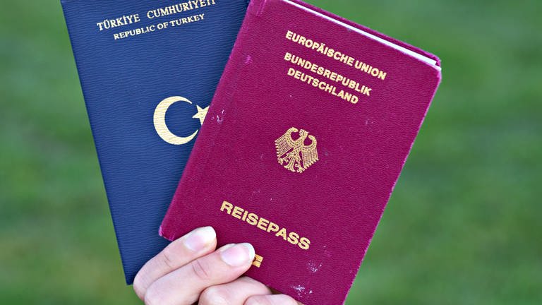 Eine Studentin zeigt einen türkischen Pass und einen deutschen Reisepass. (Foto: dpa Bildfunk, picture alliance/dpa | Daniel Bockwoldt)