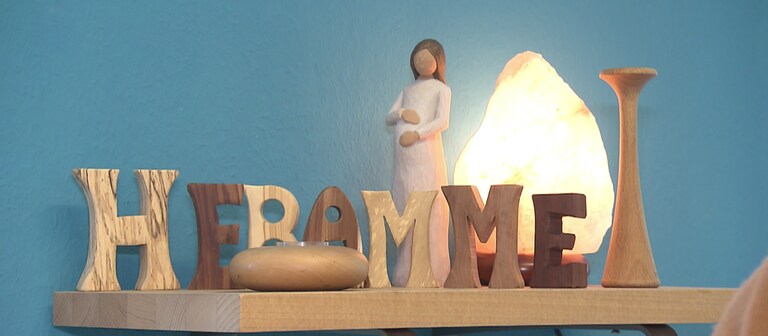 Eine schwangere Frau und das Wort Hebamme sind auf einem Tisch nachgebildet. (Foto: SWR)