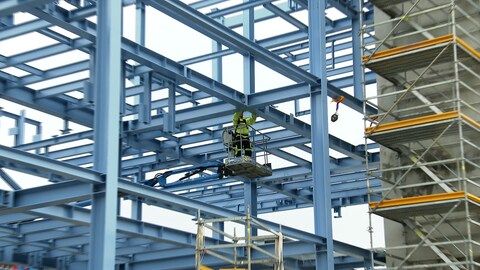 Ein Mann montiert etwas in luftiger Höhe in einem Neubau eines Gas-Werkes der EnBW. (Foto: SWR)