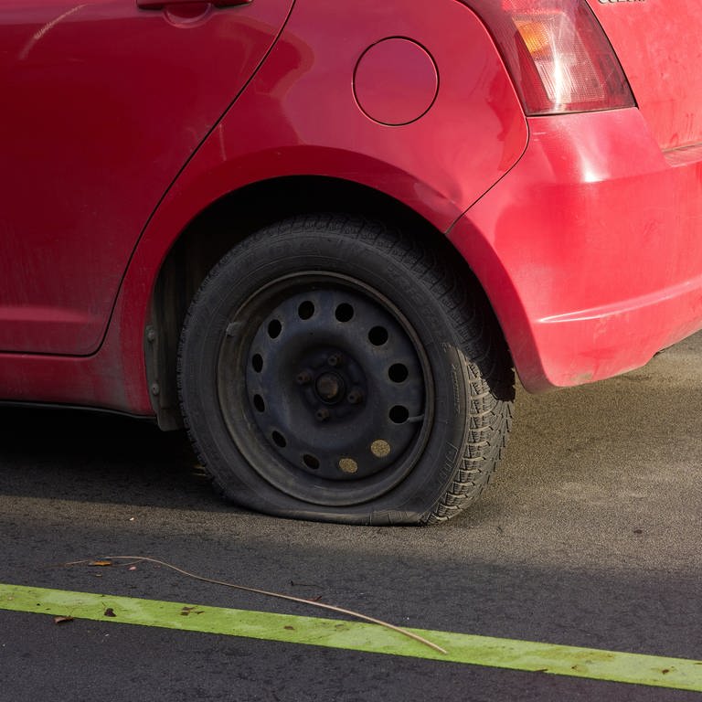 Zwei rote Autos mit platten Reifen. (Foto: dpa Bildfunk, picture alliance/dpa | Thomas Frey)